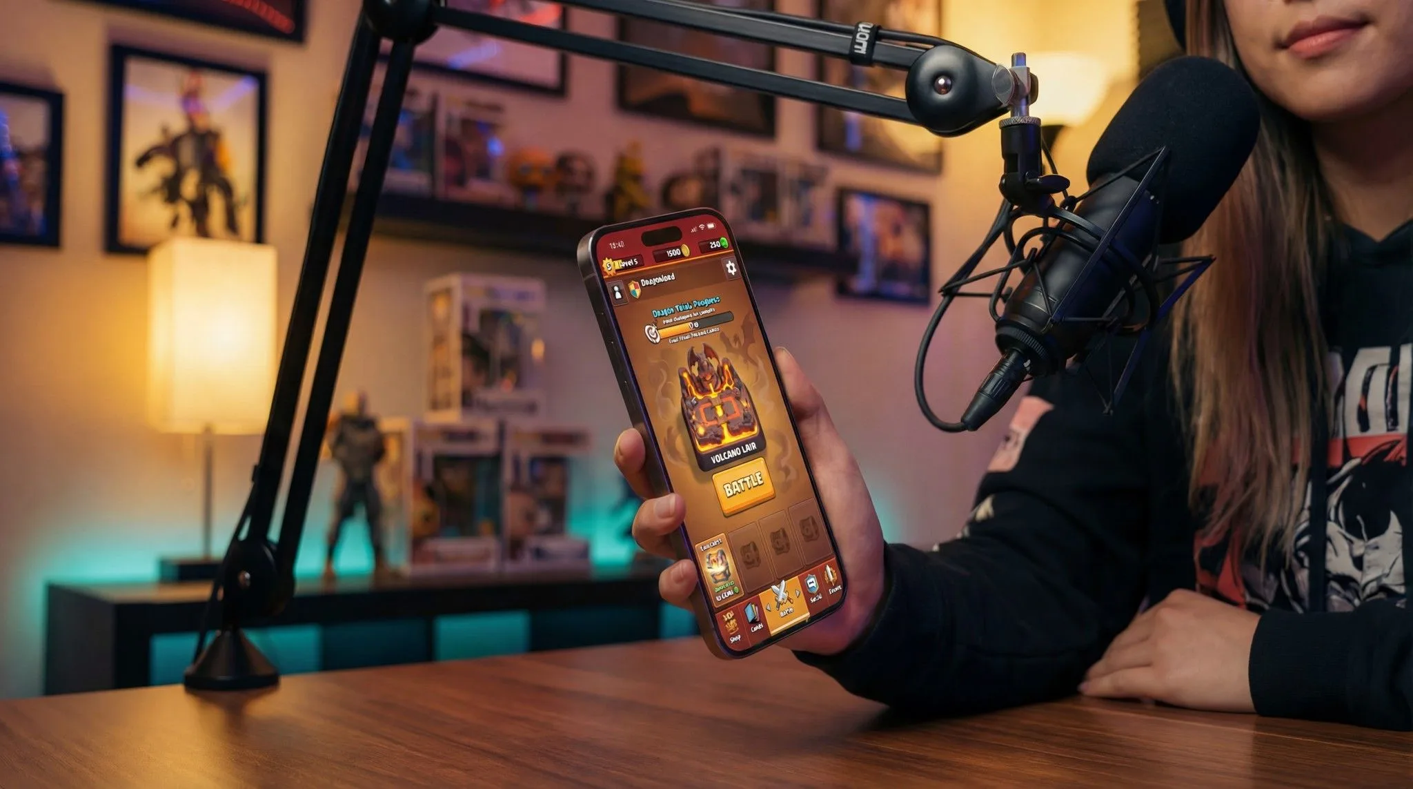 Person holding smartphone displaying mobile game with professional microphone in gaming room streaming setup