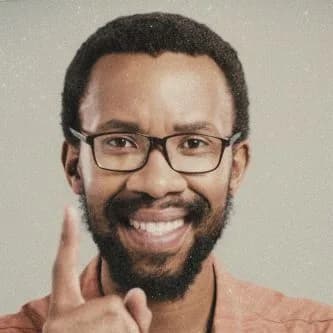 Smiling Black man wearing glasses and coral button-up shirt, professional headshot portrait