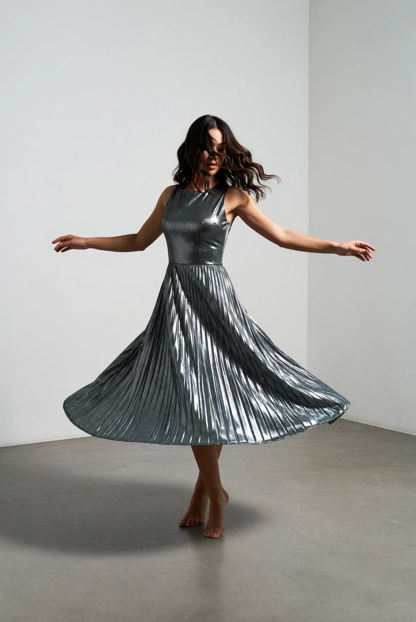 arafed woman in a silver dress is dancing in a room
