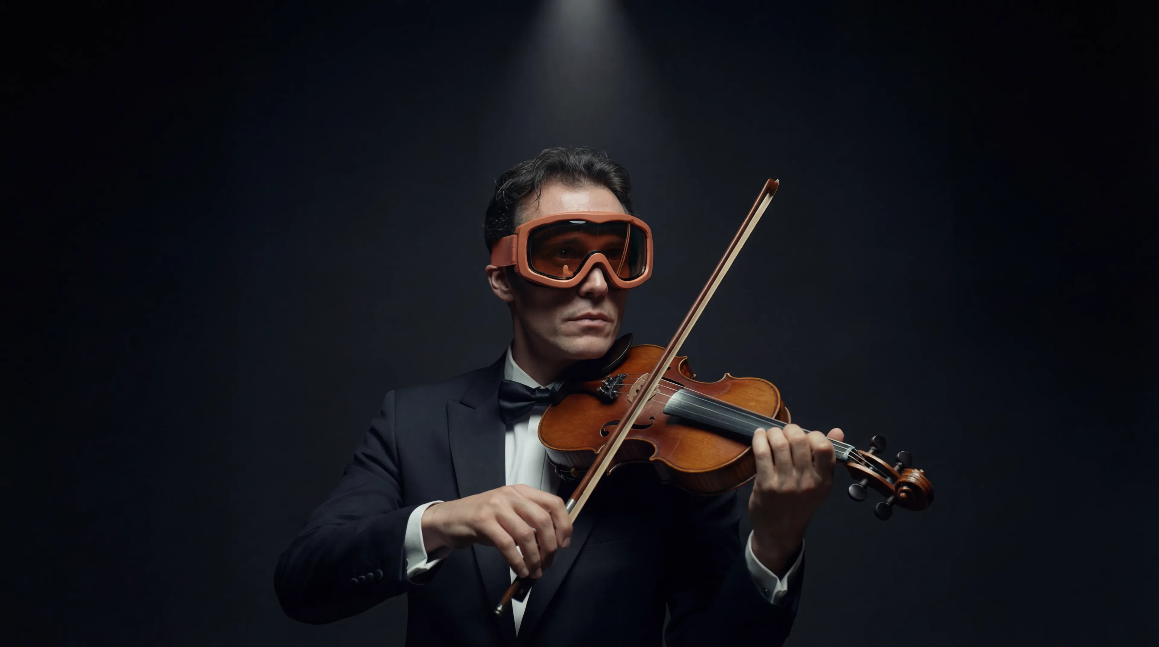Violinist in a tuxedo wearing orange ski goggles