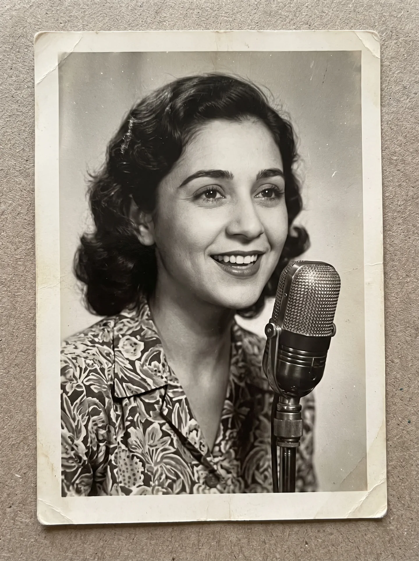Black and white photo of young Dottie smiling at a radio microphone
