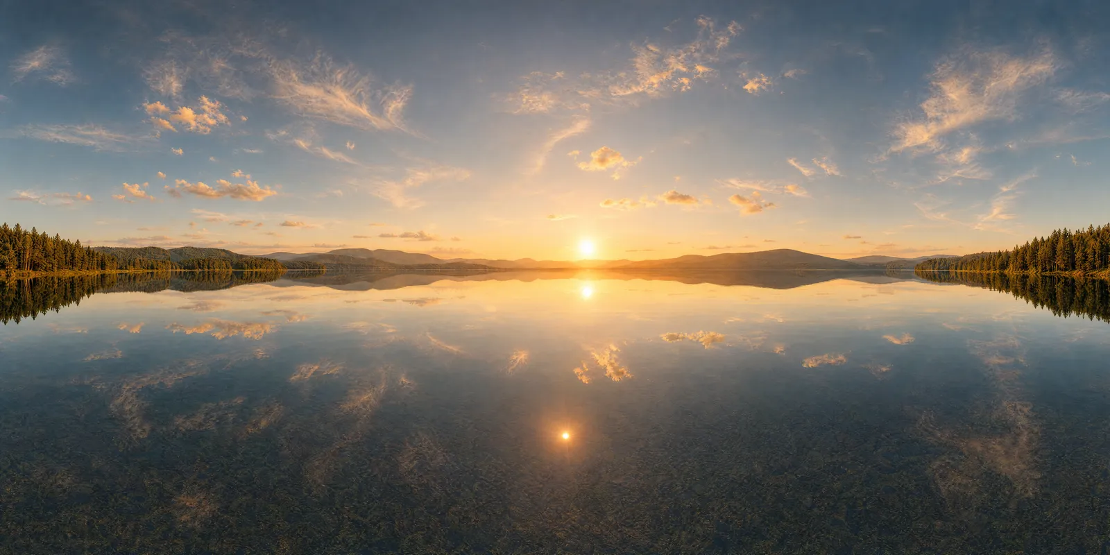 The same lake panorama at golden hour, a low sun over the water